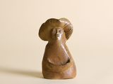 une figurine représentant une femme portant un chapeau sur la tête