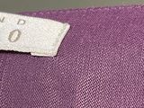 someone is holding a pair of scissors and a purple shirt
