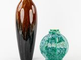 deux vases posés l'un à côté de l'autre sur une surface blanche