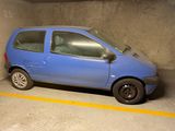 une petite voiture bleue garée dans un parking couvert