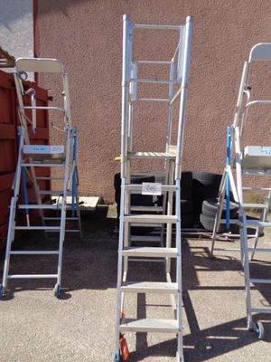 three ladders that are sitting in front of a building