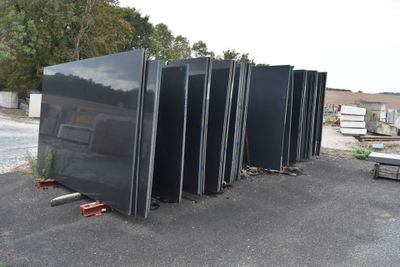 a lot of black refrigerators sitting in a parking lot