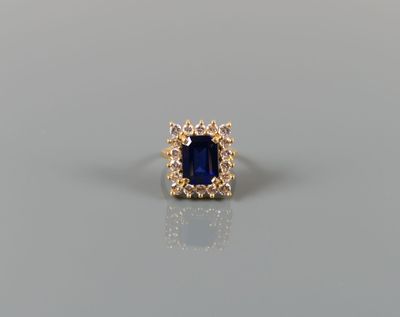 a blue sapphire and diamond ring on a gray surface