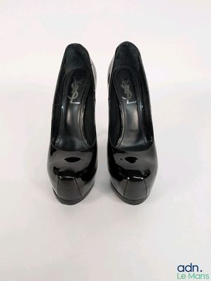 black high heeled shoes on a white surface with a white background