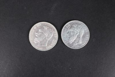 deux pièces d'argent posées côte à côte sur une surface noire