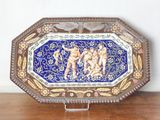 un plateau décoratif orné d'une peinture, posé sur une table en bois
