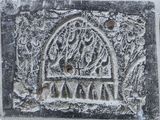 an image of a stone plaque with a bird in a cage