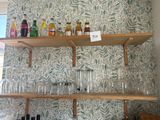 de nombreux verres et bouteilles sur les étagères de la cuisine