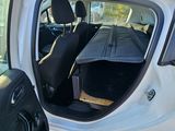 a white car with its door open and the seat up