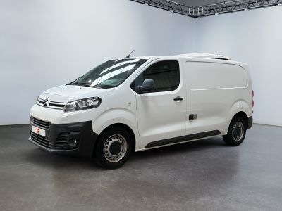 La camionnette blanche est garée dans la grande salle du bâtiment.