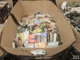 une boîte en carton remplie de livres et une paire de ciseaux