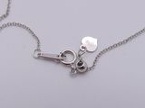 a silver necklace with a pair of scissors attached to it