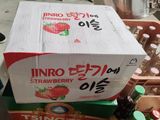 une boîte de fraises posée sur une boîte de sodas