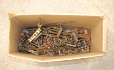 a cardboard box filled with assorted tools on the floor