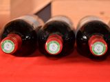 several bottles of wine are lined up on a red table