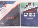 deux livres posés sur une surface blanche, avec un bateau de croisière en arrière-plan