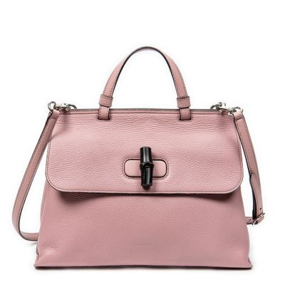 un sac à main en cuir rose orné d'une boucle métallique sur le devant