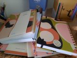 several notebooks are stacked on top of each other on a table
