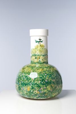 un vase vert et blanc orné d'un oiseau