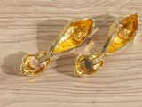 pair of gold plated earrings on a wooden surface