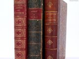 three old books sitting on top of each other on a table