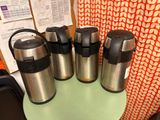 four different types of thermos are lined up on a table