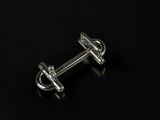 a close up of a pair of silver cufflinks on a black surface