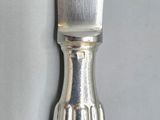 a silver knife that is sitting on top of a table
