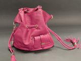 pink bucket bag with tassels and tassels on a grey background