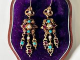 une photo d'une paire de boucles d'oreilles posée dans un étui violet