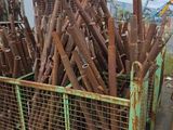 un gros tas de tuyaux métalliques rouillés dans une cage