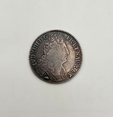une pièce d'argent posée sur une surface blanche, sur fond blanc