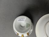 two cups and saucers sitting on a table