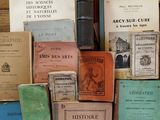 many books stacked on top of each other on a table