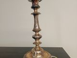 une lampe posée sur une table, sur laquelle est posé un chapeau