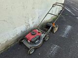 a lawn mower that is sitting on the side of the road