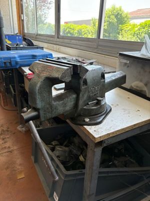 an old viset sitting on a workbench in a workshop
