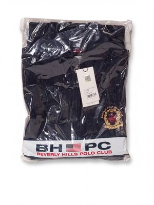 the black shirt is wrapped in plastic and has a badge on it