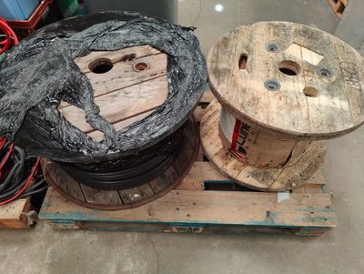 two spools on a pallet next to a wire spool