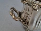 a silver vase that is sitting on a table