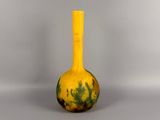 yellow and green vase sitting on top of a white table