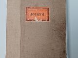 an old book sitting on top of a table next to a blue wall