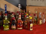 many bottles of alcohol on a table with a red table cloth
