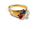 une image représentant une bague en or sertie de pierres bleues et rouges