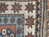a close up of a rug on a wooden floor with a cat sitting on it