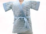 une robe bleue posée sur un support en bois à côté d'un gâteau