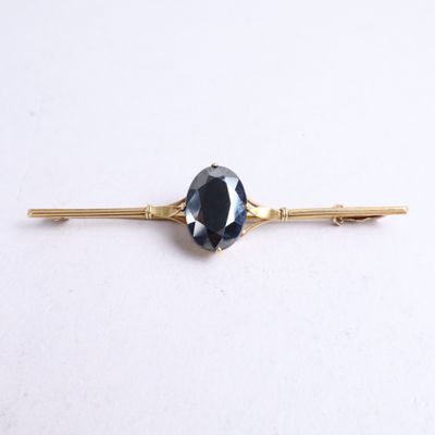a close up of a blue stone on a gold bobby pin