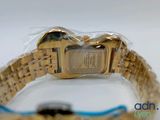 an image of a gold wrist watch wrapped in plastic on a white surface