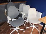 Plusieurs chaises de bureau sont alignées en rang dans une pièce