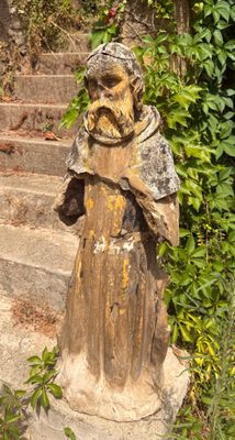 une statue représentant un moine sur les marches d'un immeuble